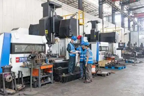 Técnicos revisando un plano junto a equipos de mecanizado tipo pórtico en un socio de manufactura colaborador